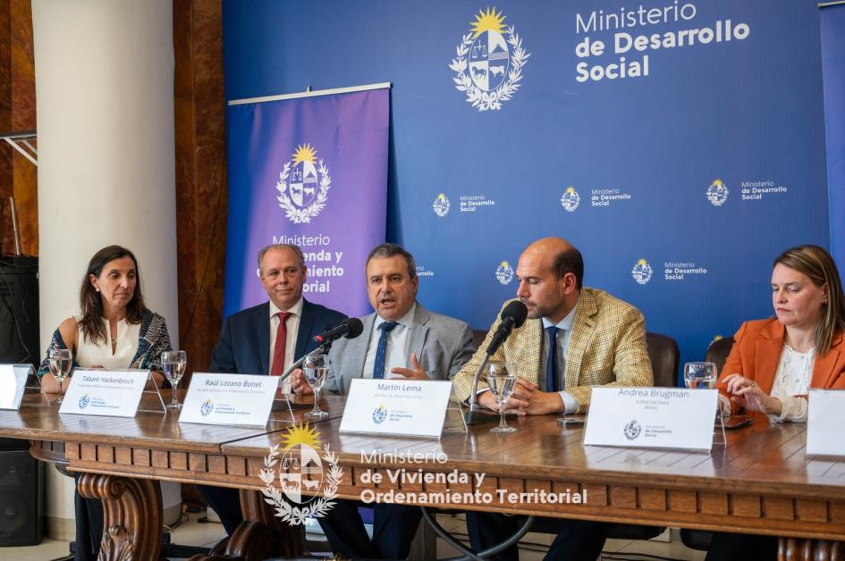 Ministro de vivienda hablando a los medios y presentes en el convenio, al lado del ministro de Mides