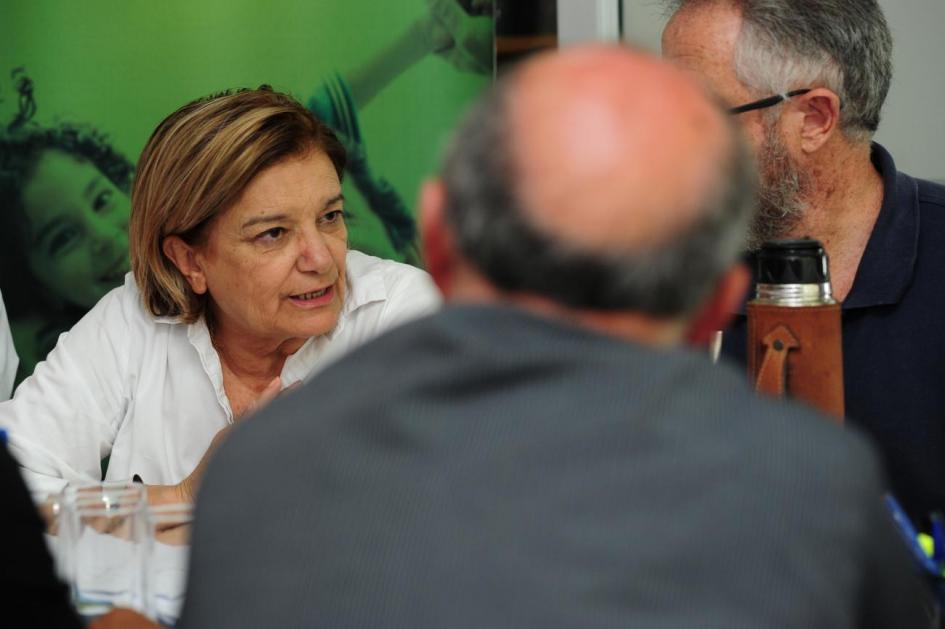 Encuentro en durazno Eneida de León y 2 hombres en una reunión