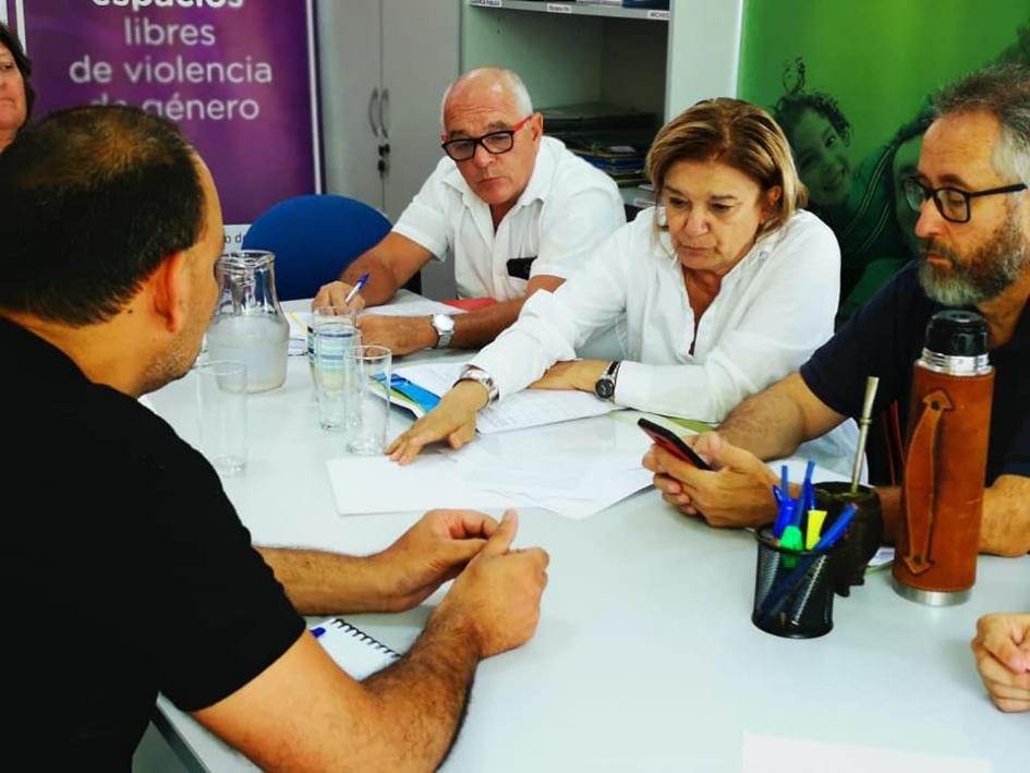 Encuentro en durazno Eneida de Leon y varias personas mirando unos documentos