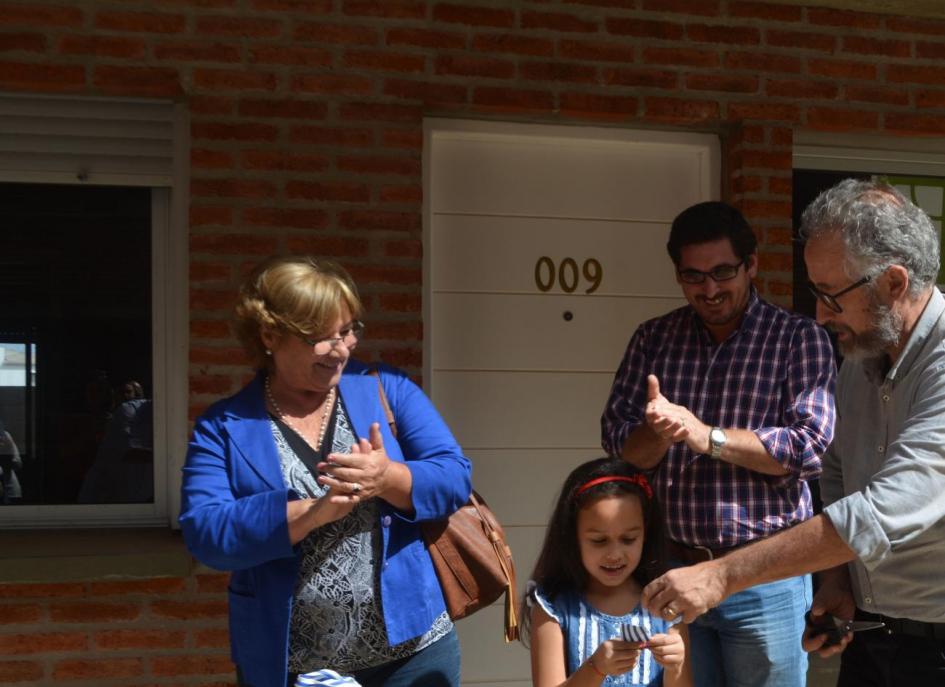 Visita al litoral Una niña recibiendo la llave de una vivienda