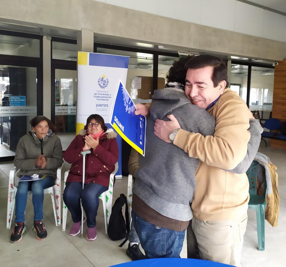 Participante recibe de manos del coordinador Rody Macías la documentación del Acuerdo particular