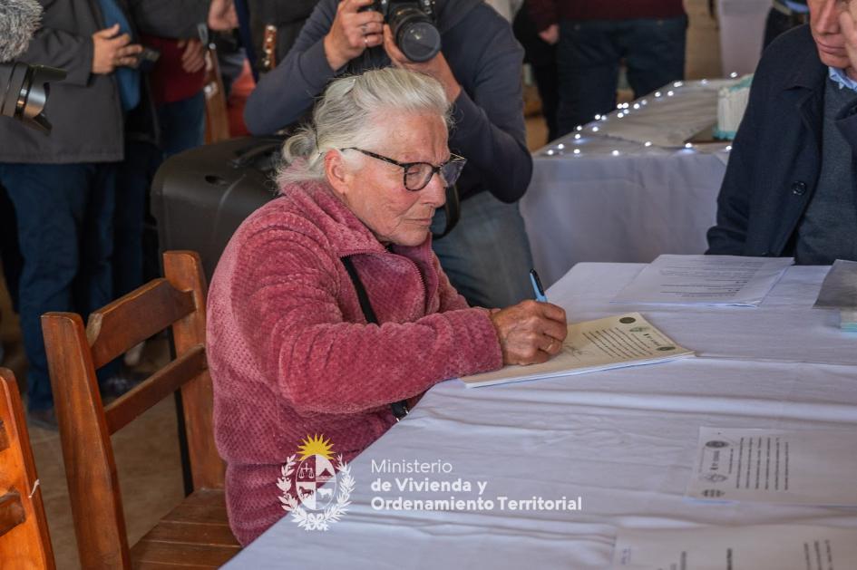 Vecina firmando escrituras de su hogar 