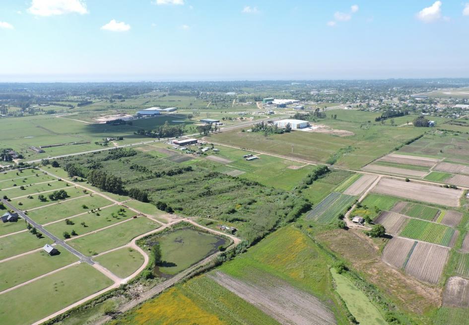 Foto aérea del departamento de Canelones, que muestra diferentes actividades realizadas en el suelo: agricultura, fábricas y zonas de viviendas.