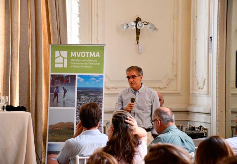 Técnico haciendo su presentación, se ve algo de público y banner con logo Mvotma 