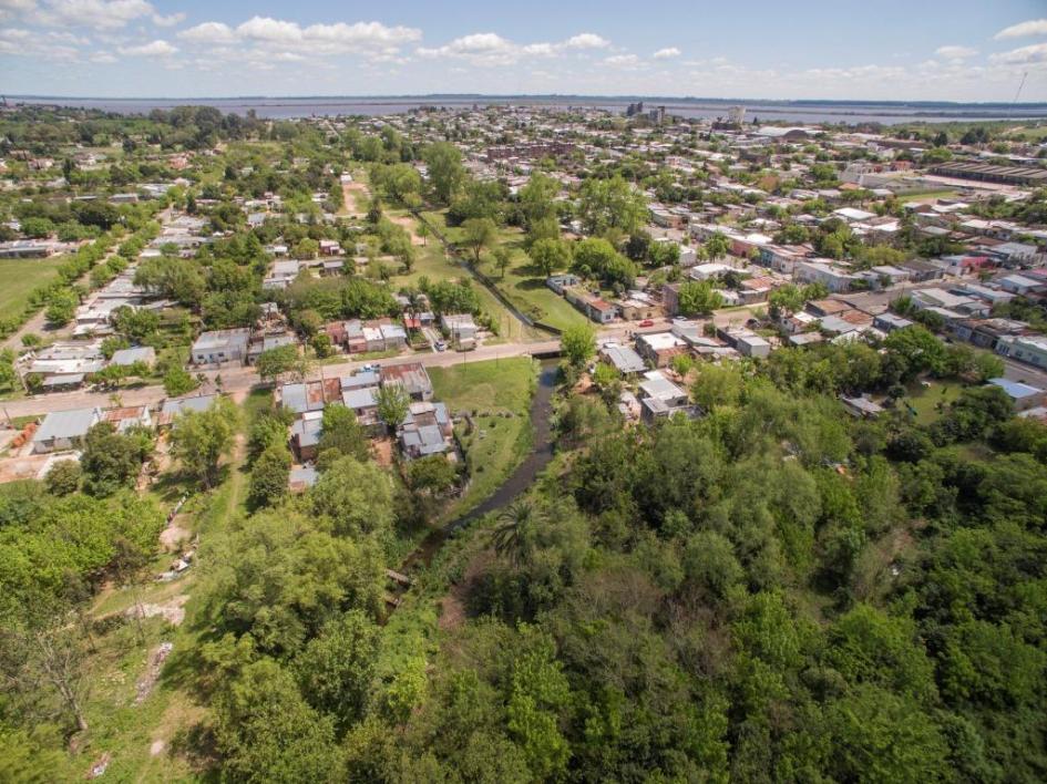 Foto área de la ciudad de Fray Bentos, que incluye un parte de la ciudad y una de arbolado.