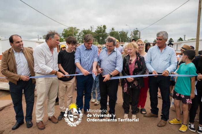 Autoridades cortando cinta de inauguración junto a vecinos