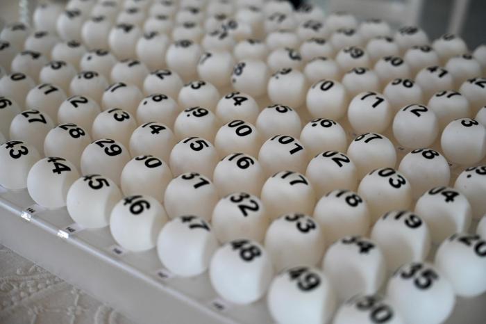 Sorteo Mevir - Los Cerrillos Bolillas con números ordenadas sobre una mesa