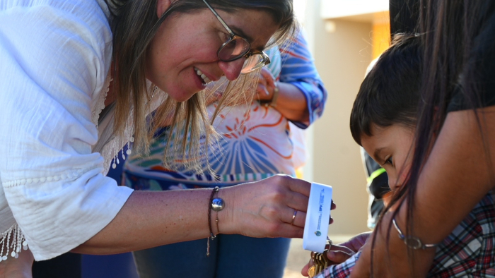 Ministra entregando llave a niño.
