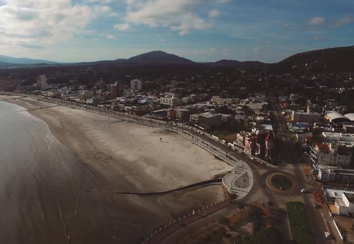 Imagen área de la ciudad de Piríapolis tomada desde el Cerro de San Antonio hacia las Sierras, donde se visualiza la playa y la Rambla de Piriápolis 