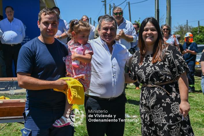 Ministro junto a una familia de Paso de los Toros muy contentos, el padre tiene a su hija en brazos