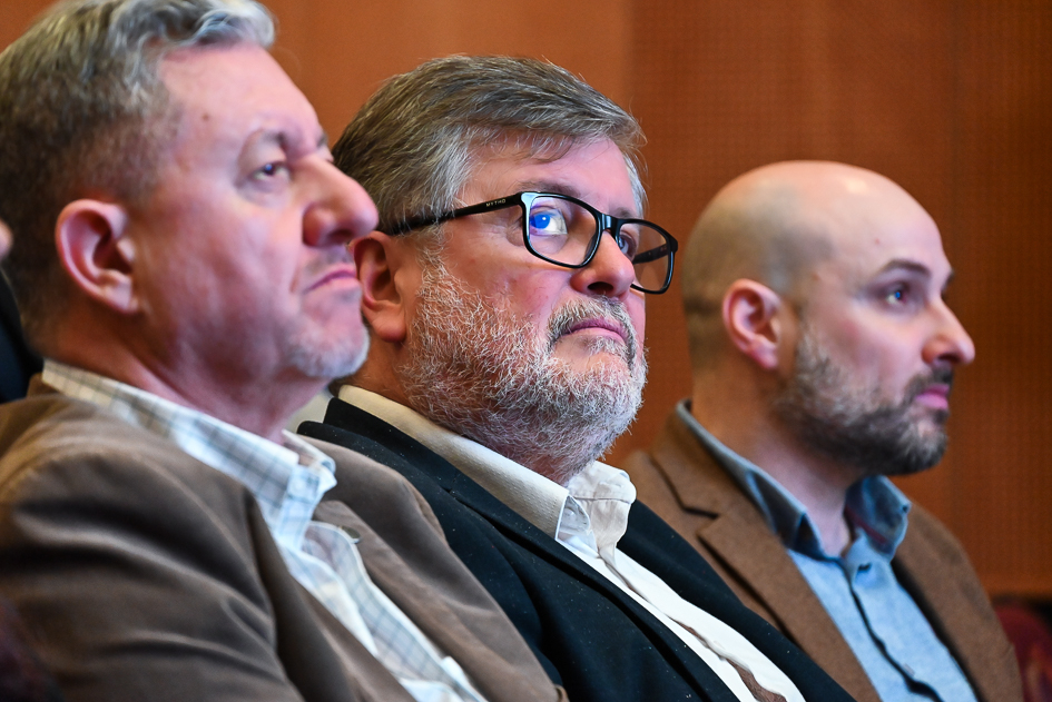 Pierre Bianchi, Sergio Pérez y Bruno Minchilli Fotografía de tres hombres sentados en un evento. Se destaca la persona del medio que es el director