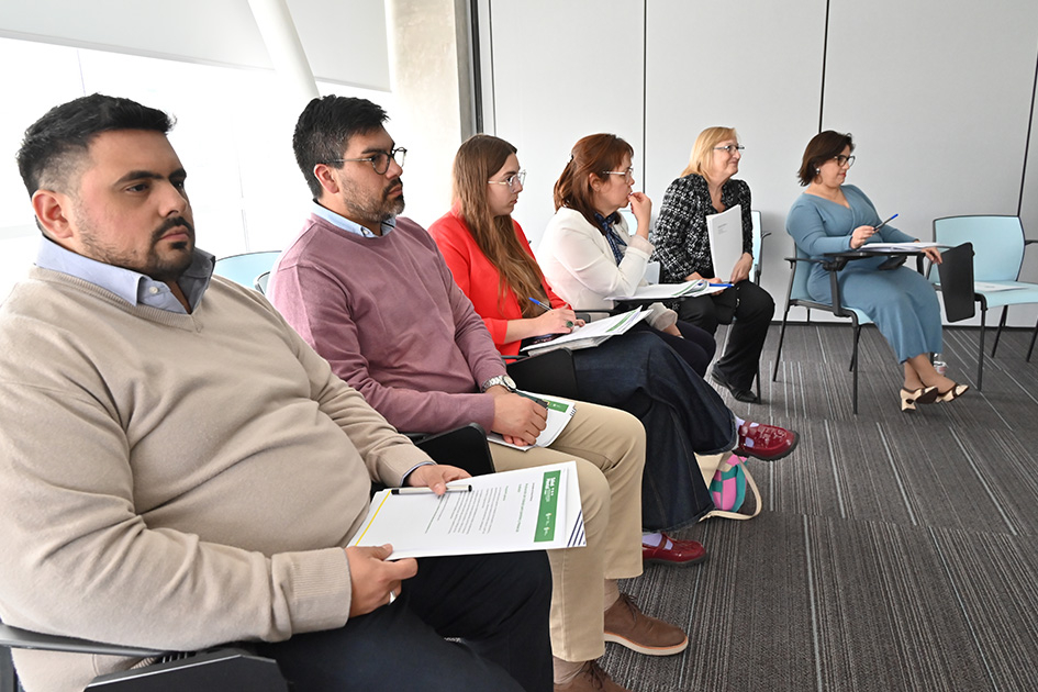 Fotografía de un grupo personas sentados en una sala.
