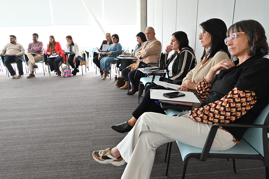 Fotografía de un grupo de personas sentados en círculo durante una reunión.