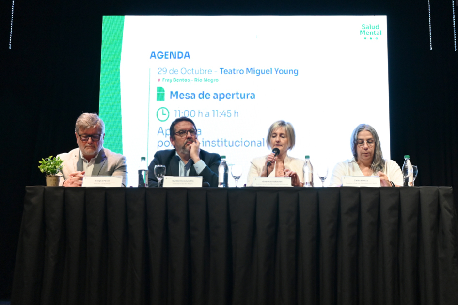 Foto de cuatro personas exponiendo en un evento formal