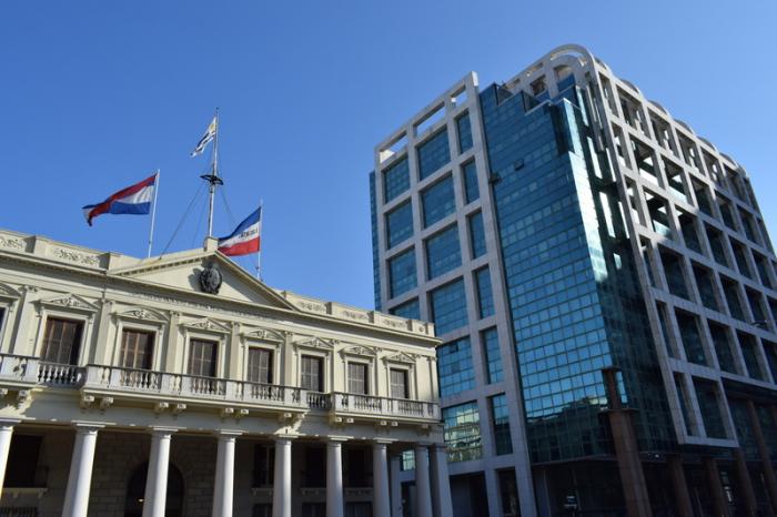 Foto. Edificio Artigas ex Palacio Estevez con las tres banderas nacionales. Detrás la Torre Ejecutiva