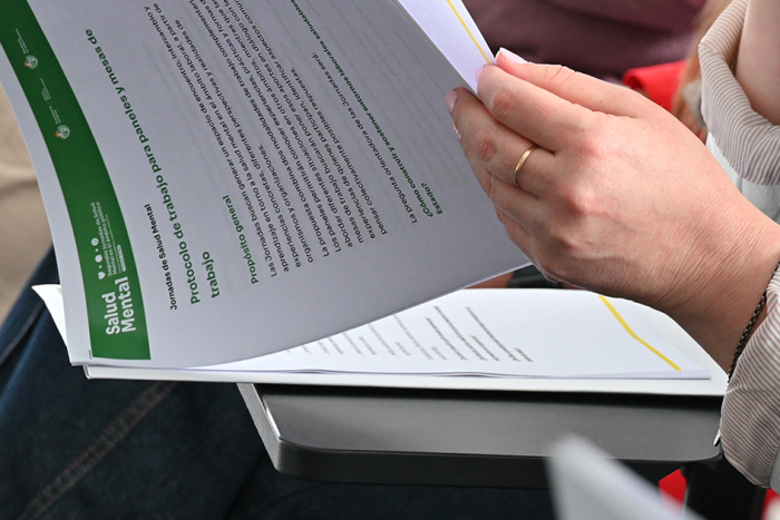 Fotografía de una persona sosteniendo un documento informativo de Salud Mental. 