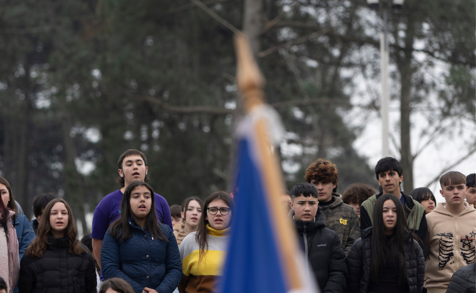 Decenas de estudiantes de la UTU de El Pinar, de pie, cantan el himno