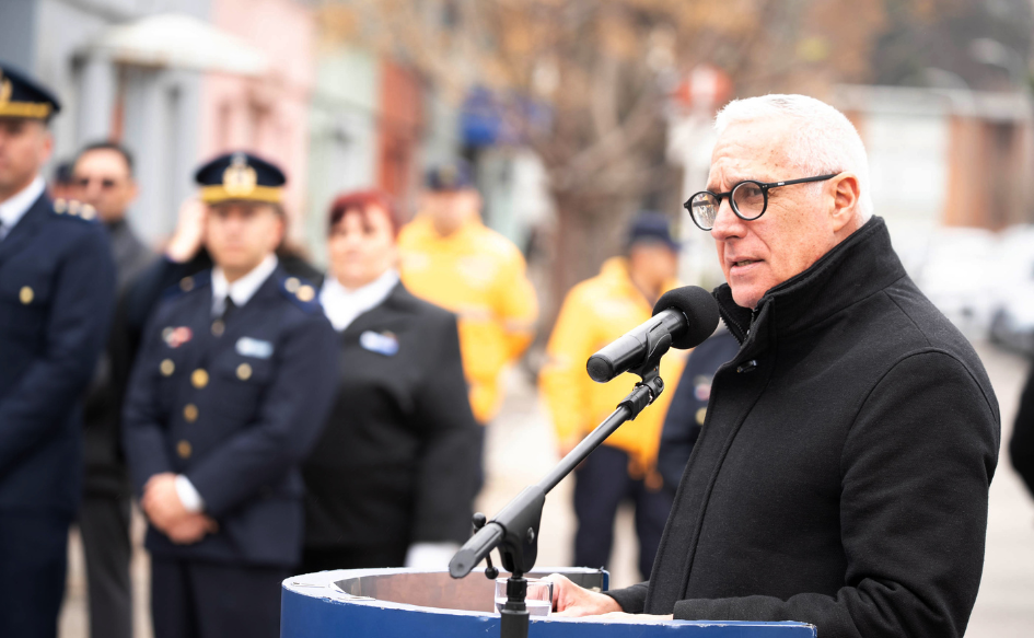 Ministro del Interior, Carlos Negro, habla detrás de un atril, en el 100° aniversario de la Policía de Tránsito de Montevideo. Detrás, policías uniformados lo escuchan atentamente
