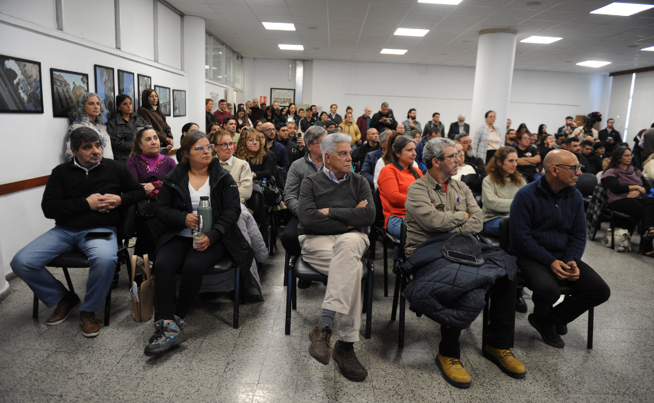 Inspector general del Trabajo, Luis Puig, sentado en primera fila con los brazos y las piernas cruzadas. A su alrededor, público sentado y de pie