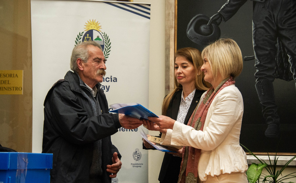La subsecretaria del Ministerio del Interior, Gabriela Valverde, entrega una carpeta al integrante de Madres y Familiares de Uruguayos Detenidos Desaparecidos, Ignacio Errandonea