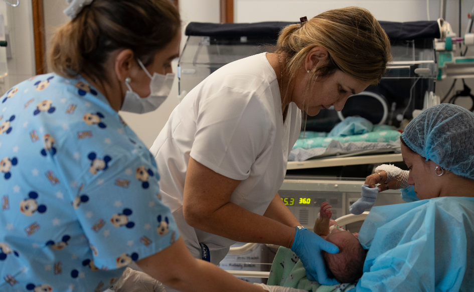 Funcionarias del Hospital de Rivera asisten a un bebé que es sostenido por su madre en el CTI neonatal del Hospital de Rivera