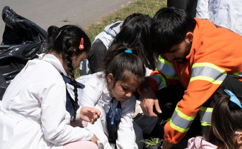 Tres niños plantan un árbol en la cañada Mones Quintela, en Cerro Norte