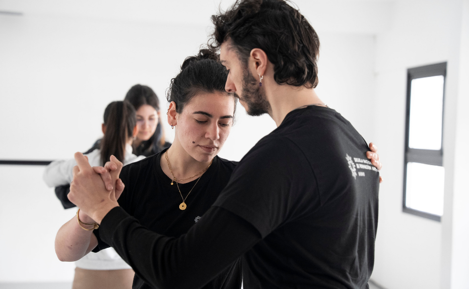 Dos estudiantes de la Escuela de Formación Artística del Sodre bailan tango en una clase