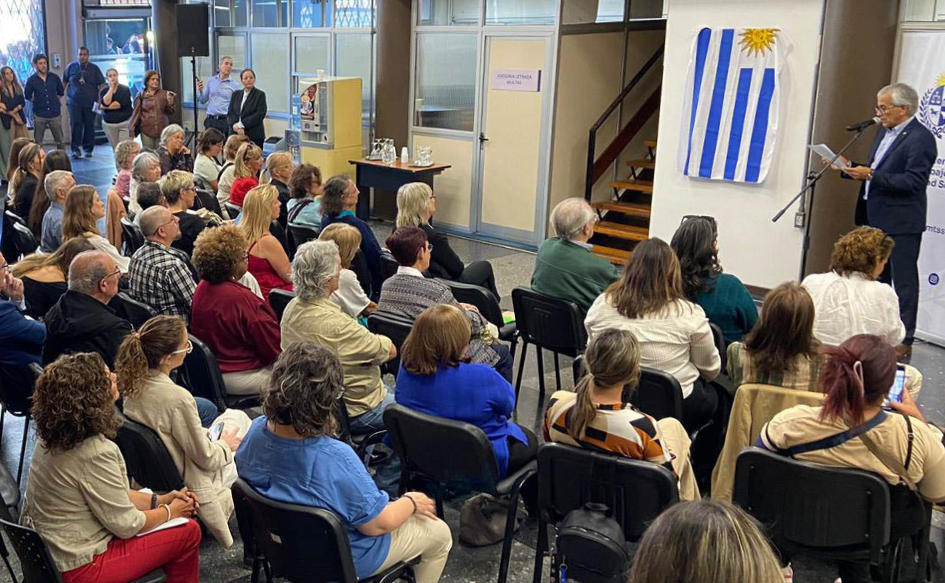 Ministro de Trabajo, Juan Castillo, lee un discurso, de pie, frente a decenas de personas, en el hall del edificio de los Consejos de Salarios
