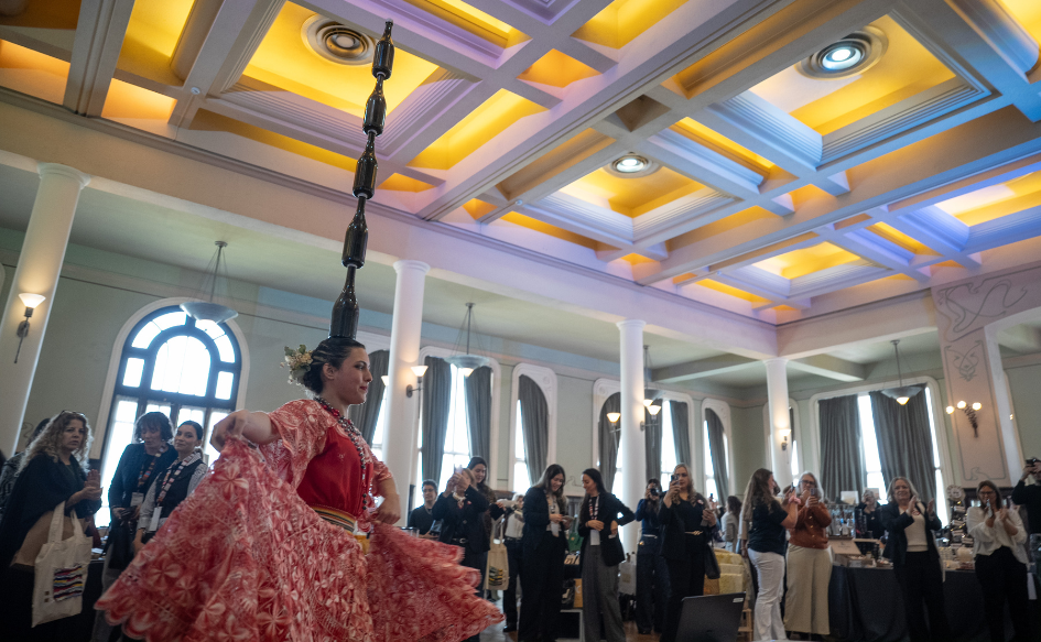 Mujer, vestida con un vestido tradicional, baila una danza durante la apertura del 13.º Encuentro de la Convergencia Empresarial de Mujeres del Mercosur.