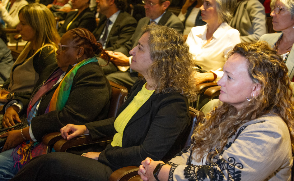 Funcionarias y funcionarios de la Cancillería, observan a presentadoras del plan de equidad de género del organismo