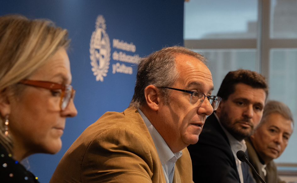 Ministro de Educación y Cultura, José Carlos Mahía, habla en conferencia. A su lado, lo observan la directora del Secan, Erika Hoffman; el director del IMPO, Miguel Lorenzoni, y el titular del Sodre, Luis Pérez Aquino