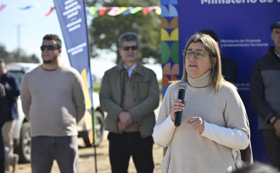 Ministra de Vivienda, Tamara Paseyro, les habla a los vecinos de Puesta al Sol, con micrófono en mano, durante la entrega de viviendas a 40 familias