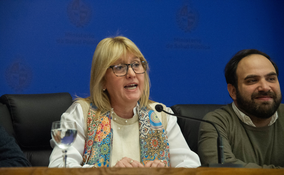 Ministra de Salud Pública, Cristina Lustemberg, habla en conferencia. A su lado, sonriente, el ministro de Desarrollo Social, Gonzalo Civila