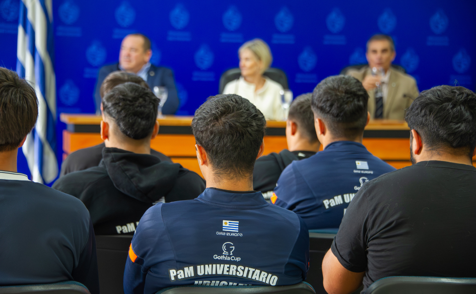 Jóvenes que forman parte del plantel de Pelota al Medio Universitario, observan a las autoridades durante el inicio de la capacitación en educación financiera