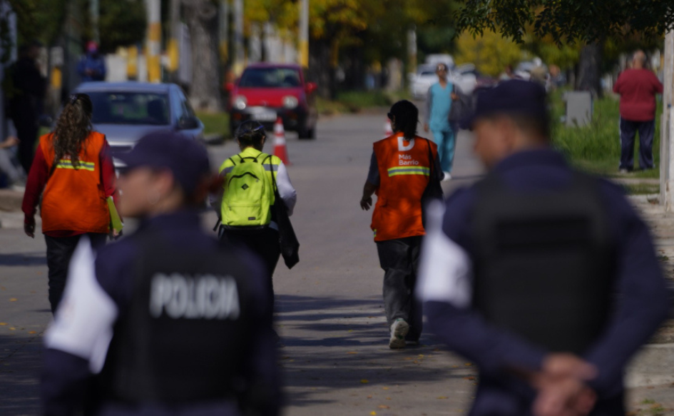 Tres censistas caminan por una calle de Cerro Norte. Detrás de ellos, un poco más lejos, caminan dos efectivos de la Policía Comunitaria