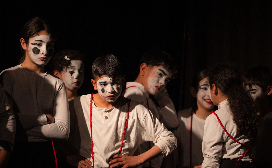 Escolares representan una obra vestidos de mimos en el escenario, durante la primera edición de La Escuela en Escena