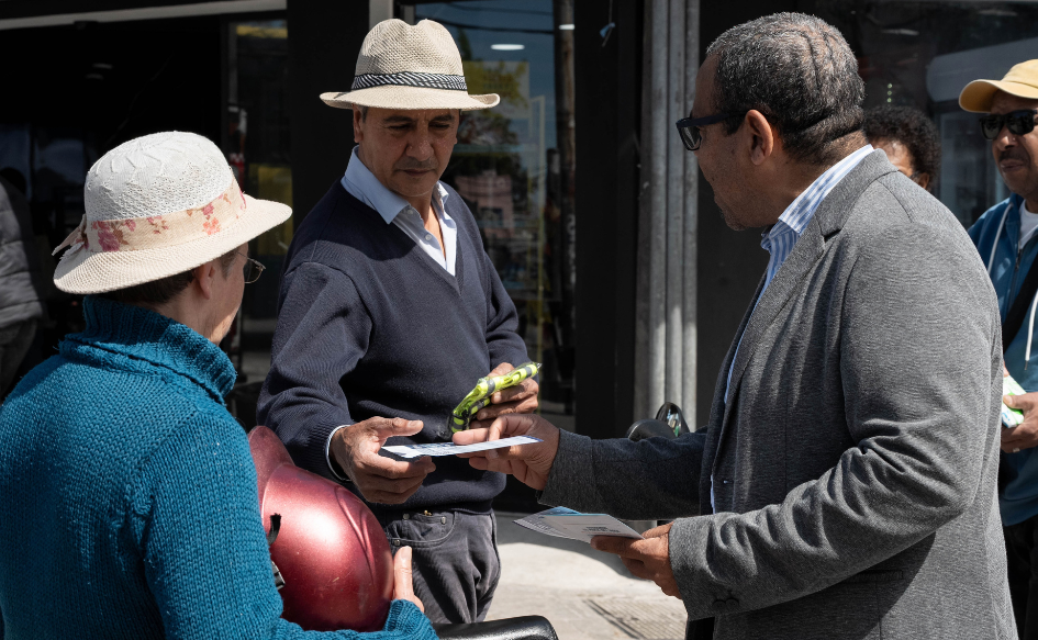 Director de Unasev, Aníbal Pintos, le entrega un folleto a un vecino, durante la jornada de sensibilización que se realizó en el Cerro de Montevideo durante la 19ª Semana de la Seguridad Vial