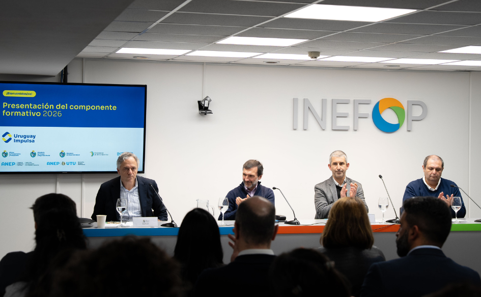 Director de OPP termina su oratoria en la presentación del componente formativo de Uruguay Impulsa para 2026. Lo aplauden, sentados a su lado, el director de Inefop, el presidente de ANEP y el presidente del Congreso de Intendentes. El público también aplaude. Detrás de Arim, la portada de su presentación con la leyenda "Presentación del componente formativo 2026" y el logo de Uruguay Impulsa