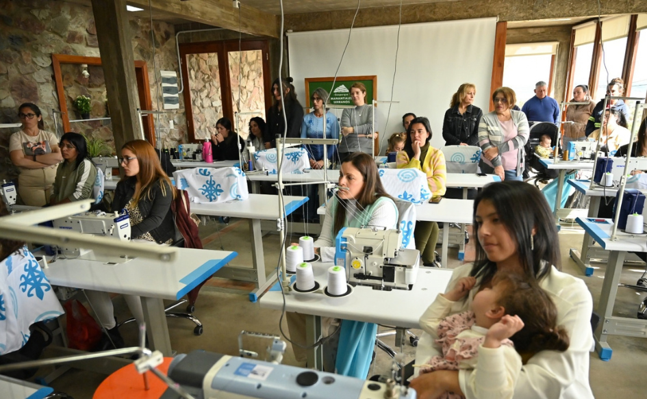Mujeres sentadas en las mesas de trabajo durante la inauguración del Centro de Costura Comunitario de la ciudad de Minas
