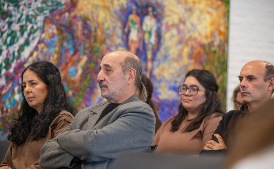 Cuatro personas, sentadas en el público, observan la presentación de AcelerIA