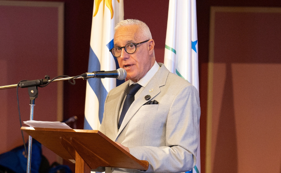 Ministro del Interior, Carlos Negro, brinda un discurso detrás de un atril, en el edificio del Mercosur, durante la apertura del encuentro "El intercambio de información para la creación de la inteligencia fronteriza". Detrás de él, el pabellón nacional y la bandera del Mercosur
