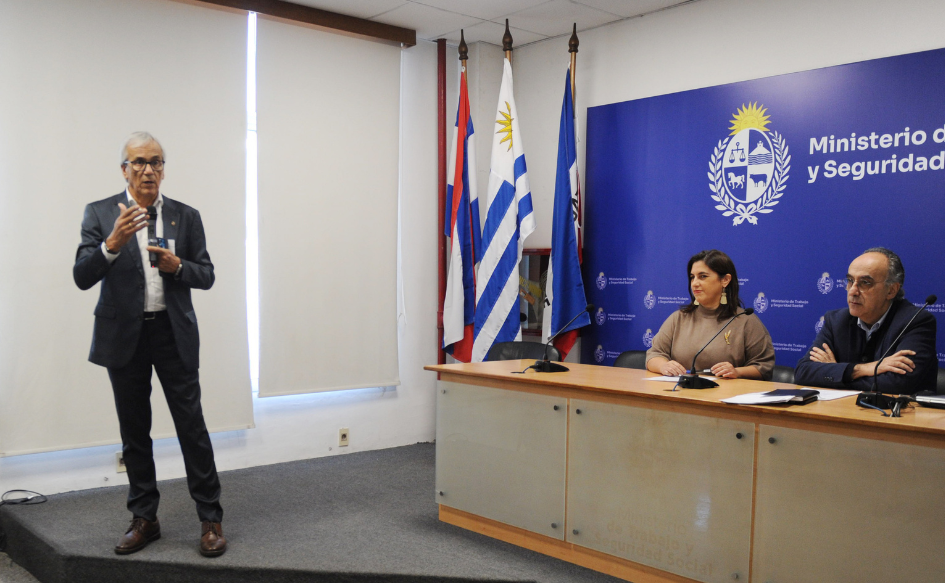Ministro de Trabajo, Juan Castillo, habla de pie, con un micrófono en la mano.