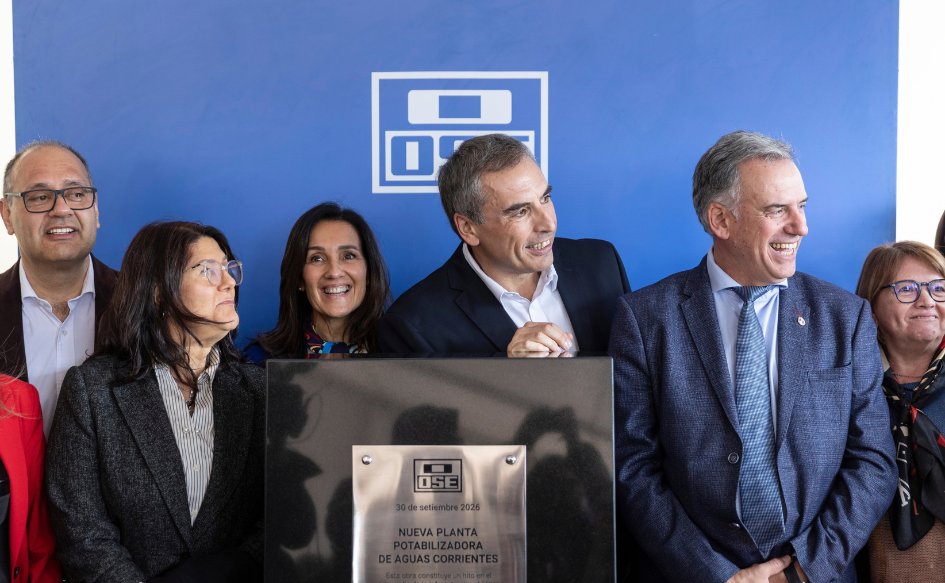 Presidente Yamandú Orsi sonríe junto al presidente de OSE, Pablo Ferreri, detrás de una placa con el logo de OSE y la inscripción "Nueva planta potabilizadora de Aguas Corrientes. 30 de setiembre de 2026"