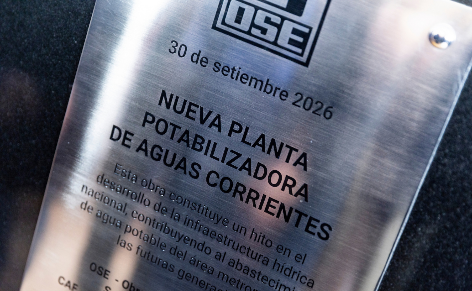 Placa con el logo de OSE y la inscripción "30 de setiembre de 2026. Nueva planta potabilizadora de Aguas Corrientes. Esta obra constituye un hito en el desarrollo de la infraestructura hídrica nacional, contribuyendo al abastecimiento de agua potable del área metropolitana y las futuras generaciones"