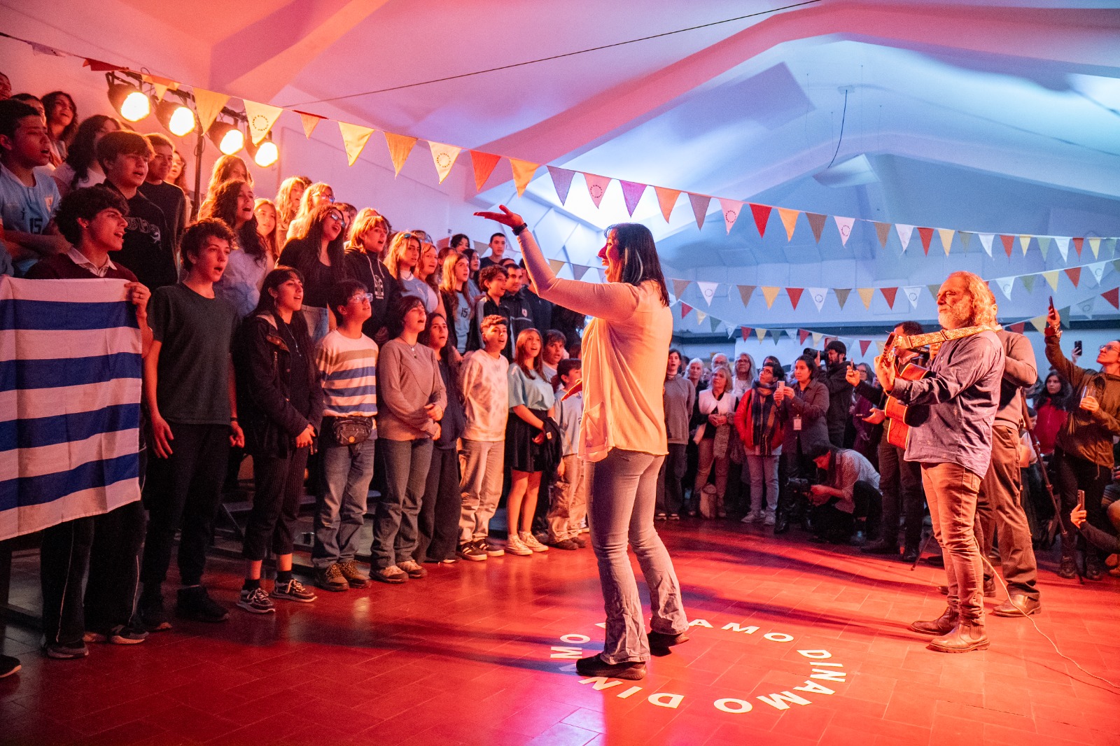 Coro de niños y adultos con bandera de Uruguay