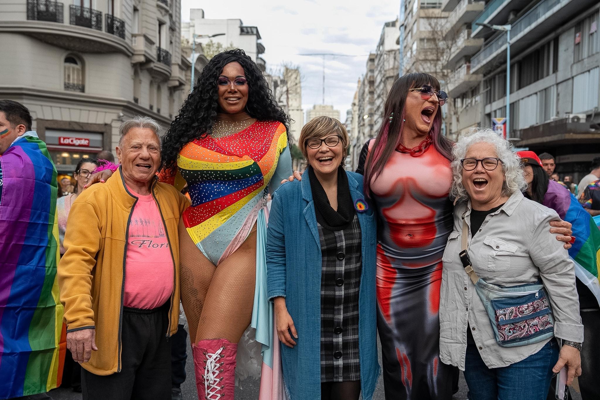 Secretaria de Derechos Humanos, Iliana Da Silva, se abraza sonriente con tres participantes de la Marcha de la Diversidad, en la plaza Cagancha
