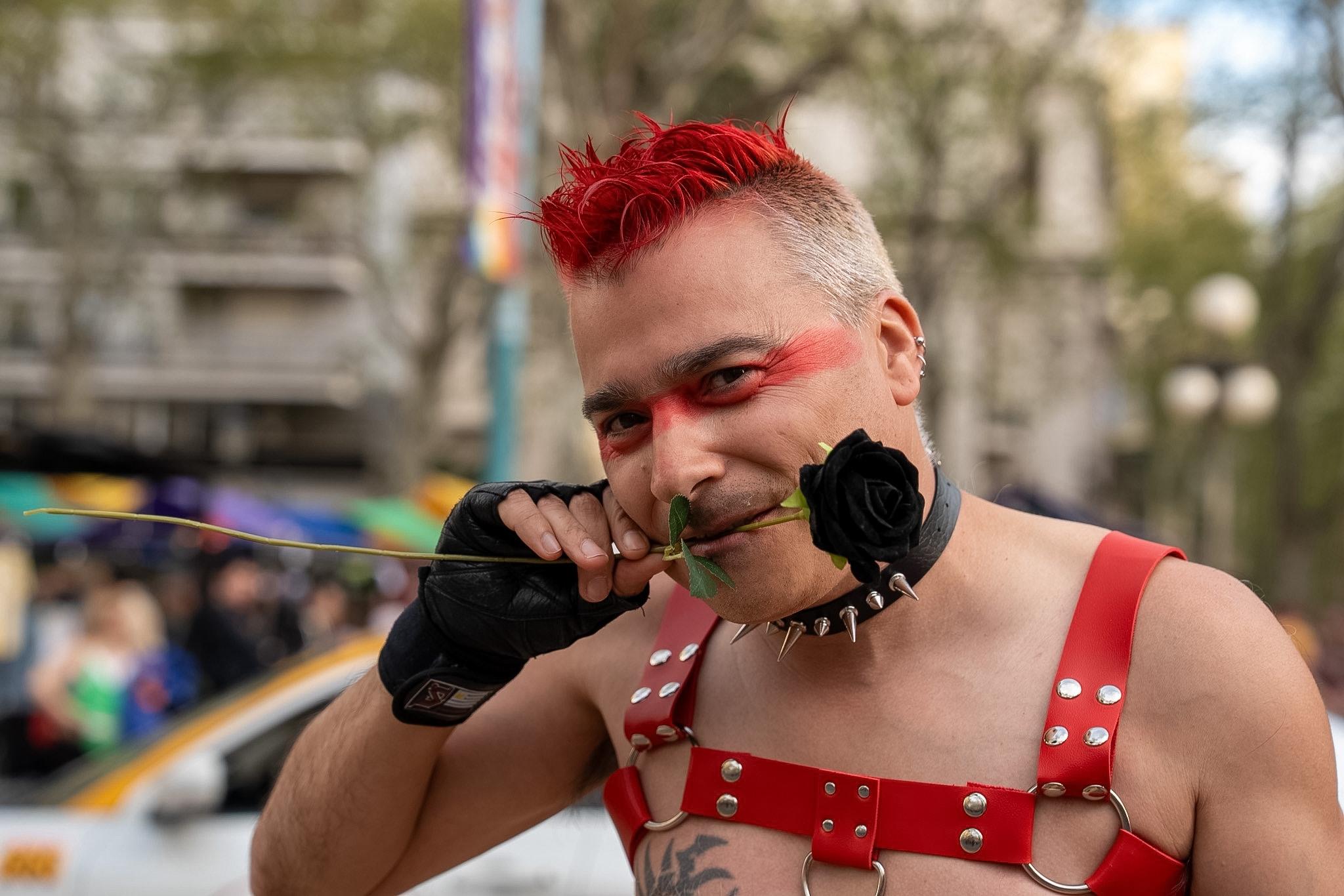 Participante de la Marcha de la Diversidad sostiene una flor negra con su boca, mientras mira a la cámara, durante la Marcha de la Diversidad