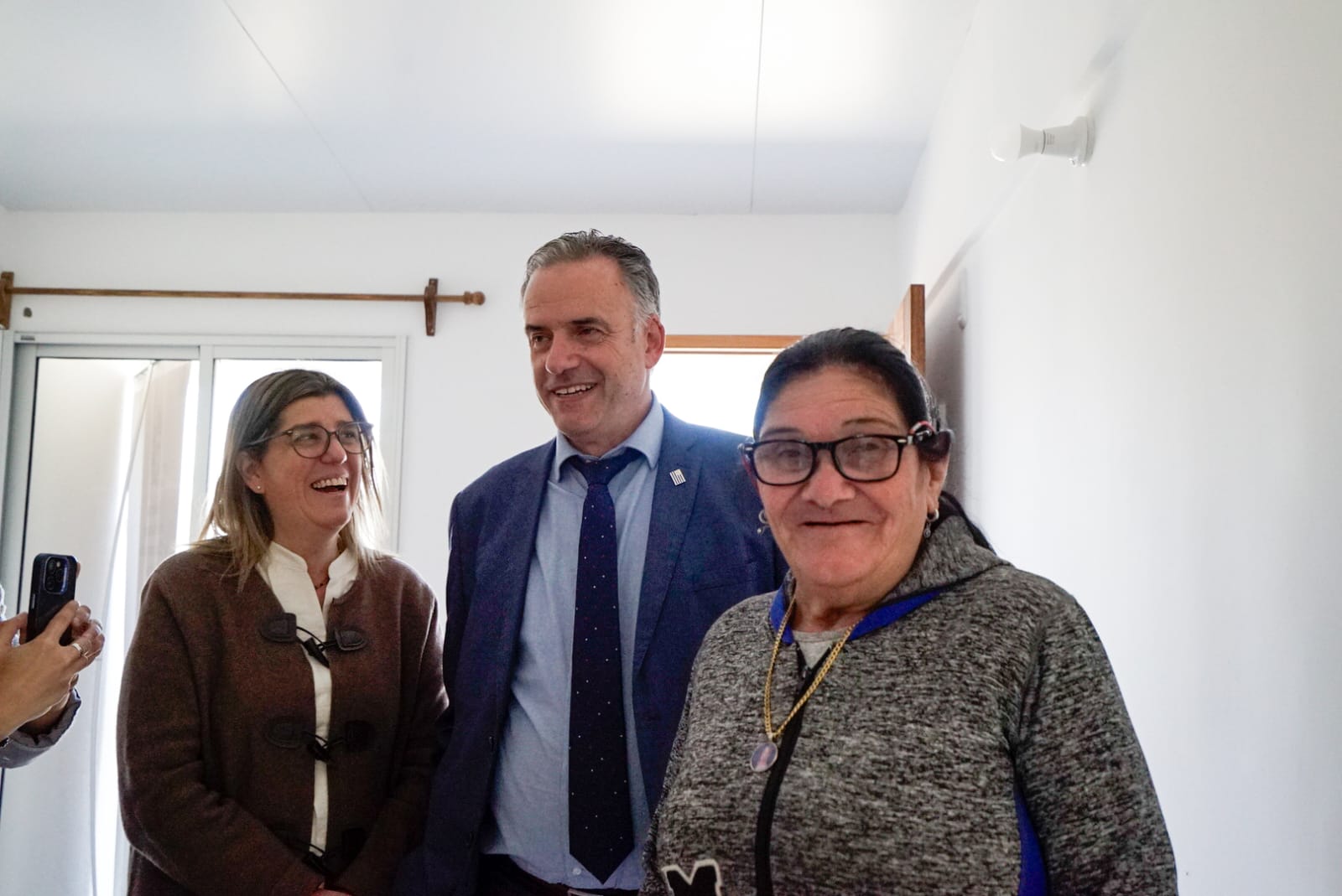Ministra Paseyro, presidente Orsi y beneficiaria de vivienda en Campo Galusso