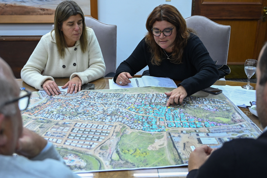 Ministra Paseyro sentada mirando mapa de las obras de realojo