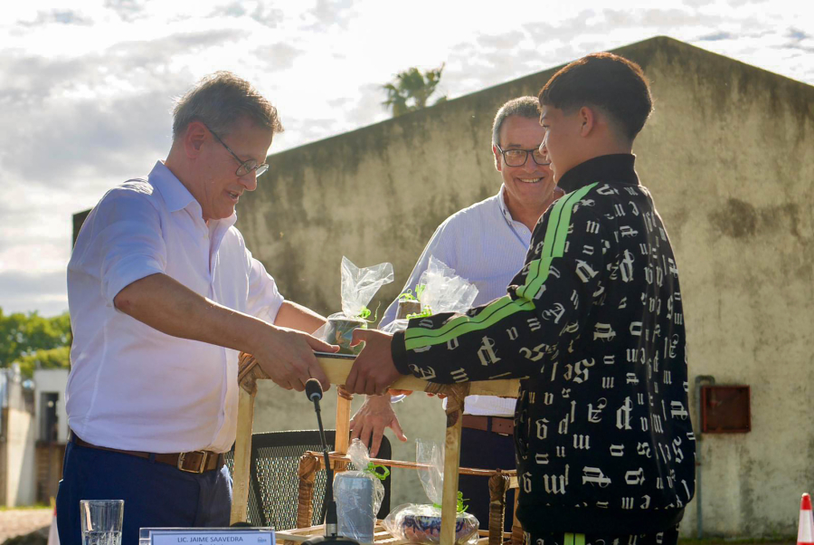 Joven del Inisa entrega obsequio a Jorge Díaz, acompañado por Jaime Saavedra